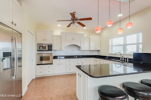4013 Haiti St, Bay Saint Louis, MS 39520 - kitchen featuring stainless steel appliances, dark countertops, a sink, hanging light fixtures, and ceiling fan