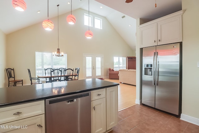 4013 Haiti St, Bay Saint Louis, MS 39520 - kitchen with tile patterned floors, dark countertops, decorative light fixtures, high vaulted ceiling, and appliances with stainless steel finishes