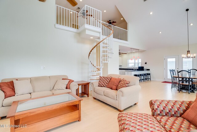 4013 Haiti St, Bay Saint Louis, MS 39520 - living area with recessed lighting, ceiling fan with notable chandelier, wood finished floors, stairway, and high vaulted ceiling