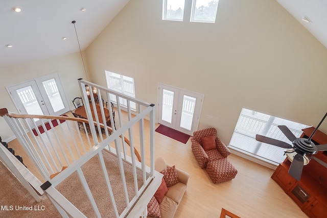 4013 Haiti St, Bay Saint Louis, MS 39520 - stairway featuring high vaulted ceiling, a healthy amount of sunlight, french doors, and wood finished floors
