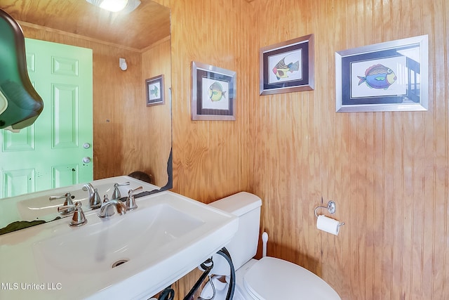 4013 Haiti St, Bay Saint Louis, MS 39520 - half bathroom featuring wooden walls, toilet, and a sink