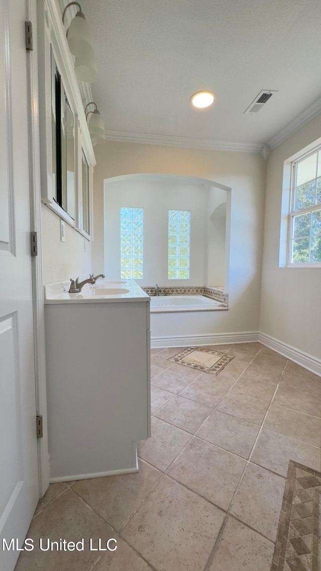 bathroom with a washtub, vanity, tile patterned floors, and ornamental molding