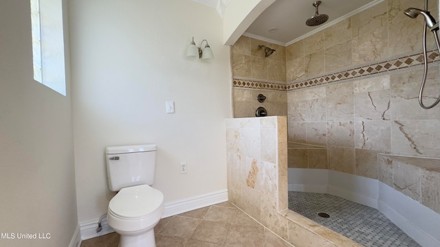 bathroom with crown molding, toilet, and tiled shower