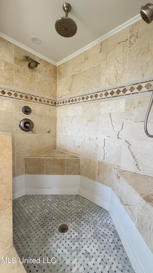 bathroom with a tile shower, tile patterned floors, and ornamental molding