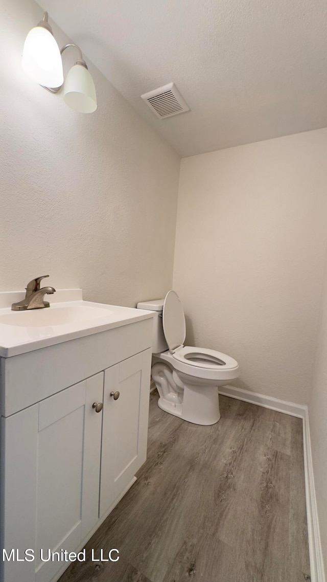 bathroom featuring hardwood / wood-style floors, vanity, and toilet