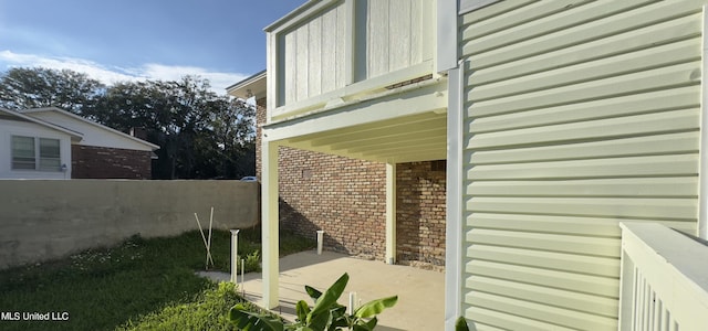 view of side of property with a balcony and a patio area