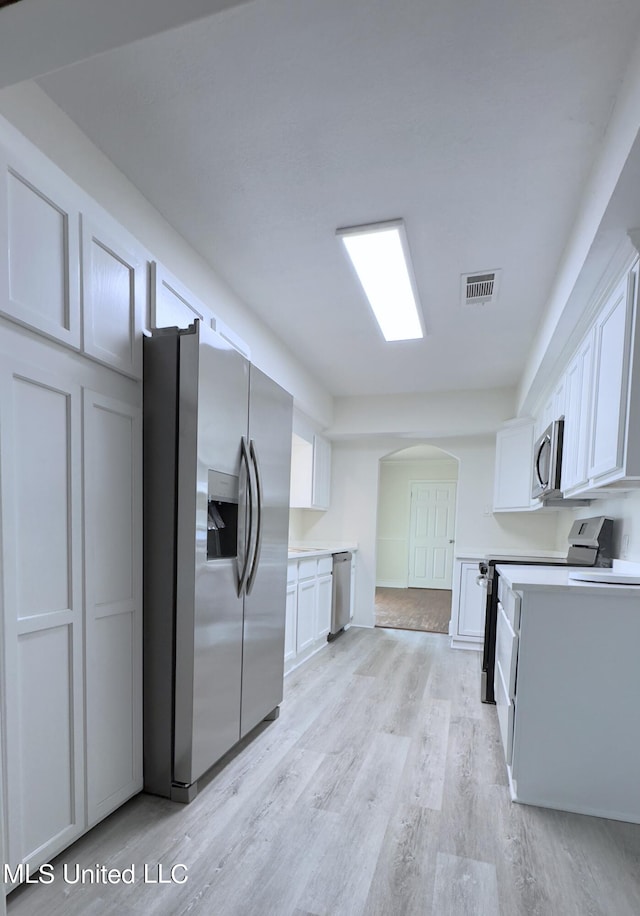 kitchen featuring white cabinetry, light wood-type flooring, and appliances with stainless steel finishes