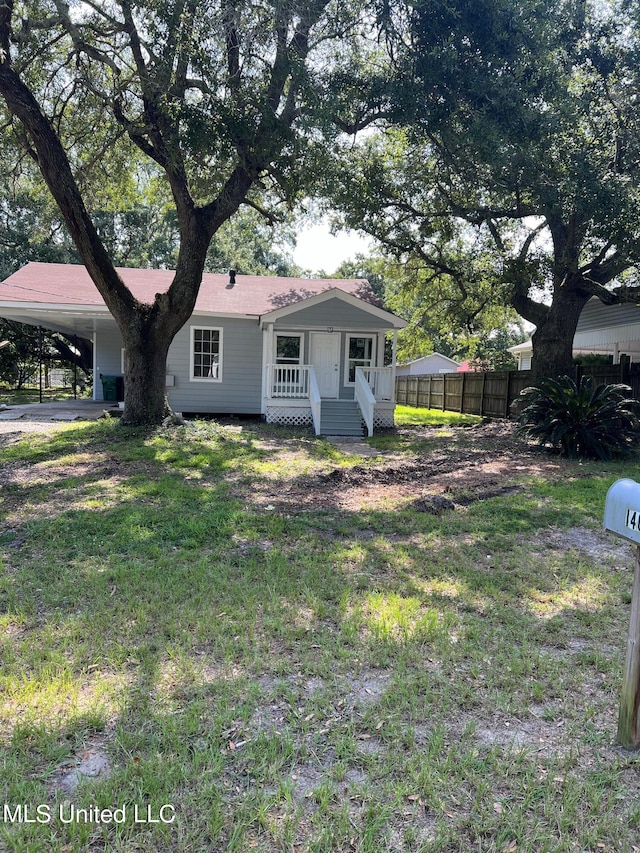 ranch-style house with covered porch, a carport, and a front lawn