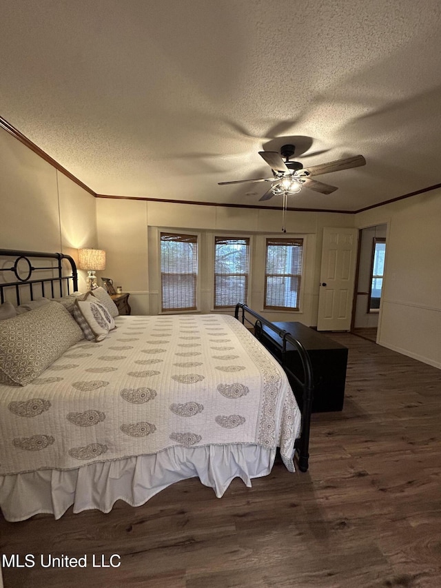 bedroom with a textured ceiling, dark hardwood / wood-style flooring, and ornamental molding