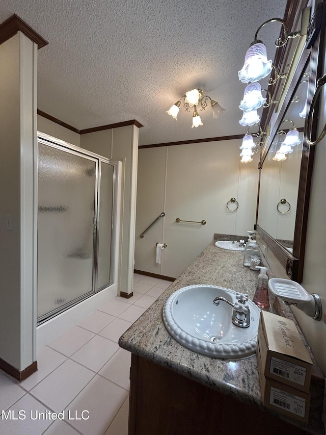 bathroom with tile patterned floors, a shower with door, crown molding, and vanity