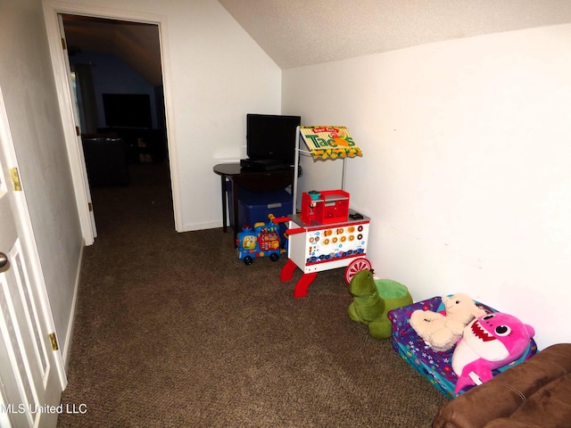 rec room with dark colored carpet, vaulted ceiling, and a textured ceiling