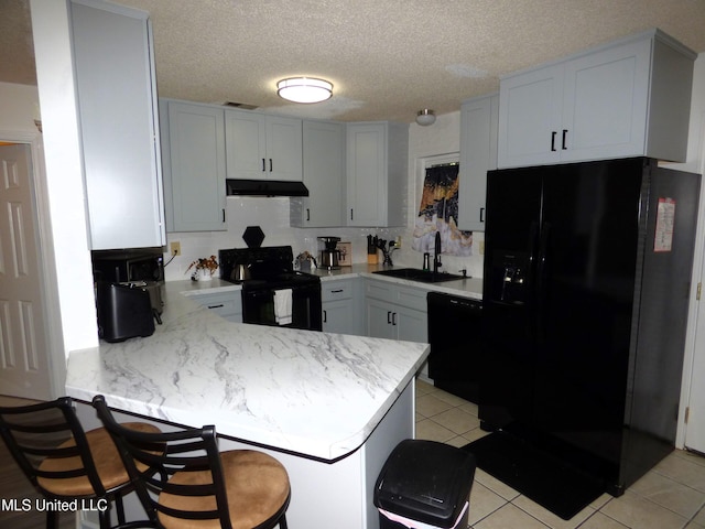 kitchen featuring sink, kitchen peninsula, white cabinets, and black appliances