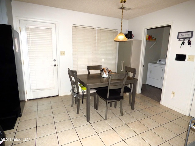 dining area with washer / clothes dryer, a textured ceiling, and light tile patterned floors