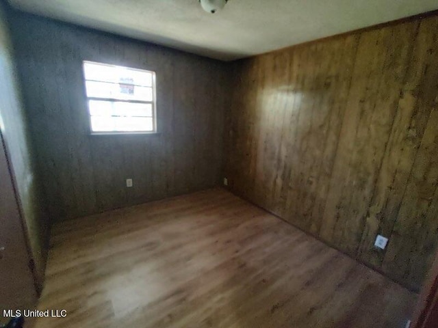 empty room with wooden walls and wood-type flooring