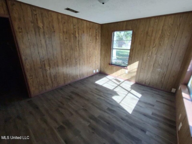 spare room with dark hardwood / wood-style floors and wooden walls