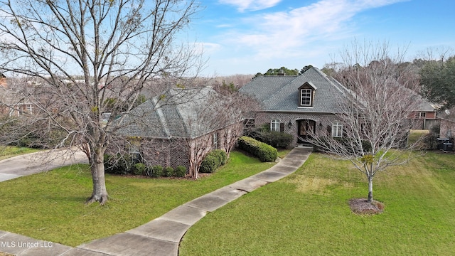 view of front of home with a front lawn and brick siding