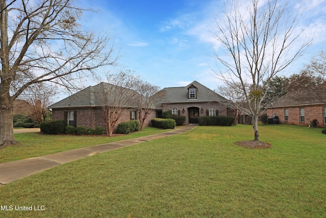 view of front of house featuring brick siding and a front yard