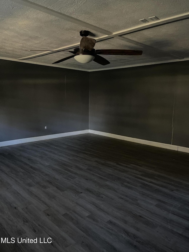 spare room with ceiling fan, dark wood-type flooring, and a textured ceiling