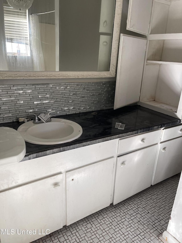 bathroom featuring tile patterned floors, vanity, and backsplash