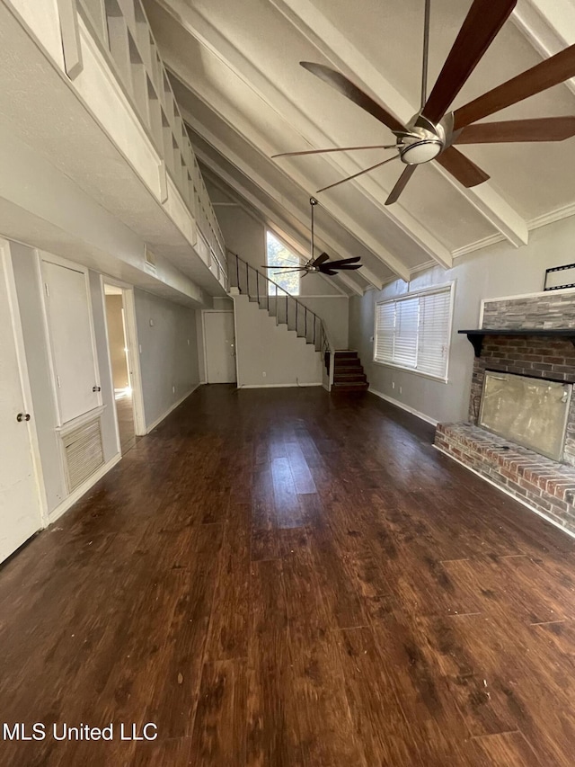 unfurnished living room with a fireplace, vaulted ceiling with beams, ceiling fan, and dark wood-type flooring