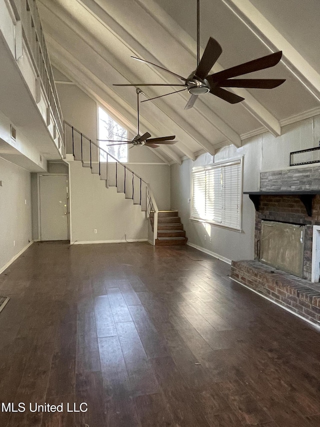 unfurnished living room with plenty of natural light, lofted ceiling with beams, a fireplace, and ceiling fan