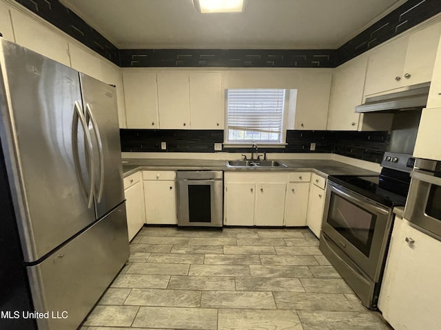 kitchen with sink, white cabinetry, stainless steel appliances, and range hood