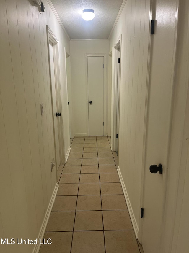 850 Friendship Rd, Ashland, MS 38603 - hallway with light tile patterned flooring, ornamental molding, a textured ceiling, baseboards, and wood walls