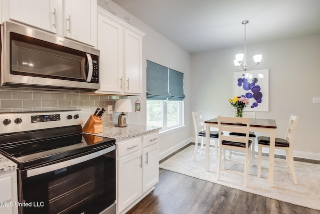 11625 Talla Dr, Ocean Springs, MS 39564 - kitchen featuring stainless steel appliances, dark wood finished floors, backsplash, a chandelier, and white cabinets