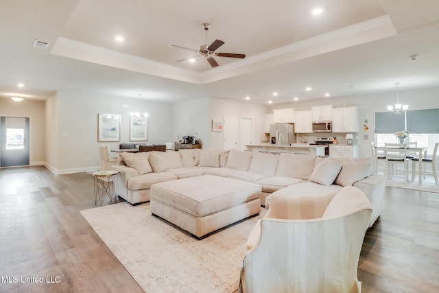 11625 Talla Dr, Ocean Springs, MS 39564 - living area featuring a chandelier, a tray ceiling, light wood-style flooring, recessed lighting, and ceiling fan