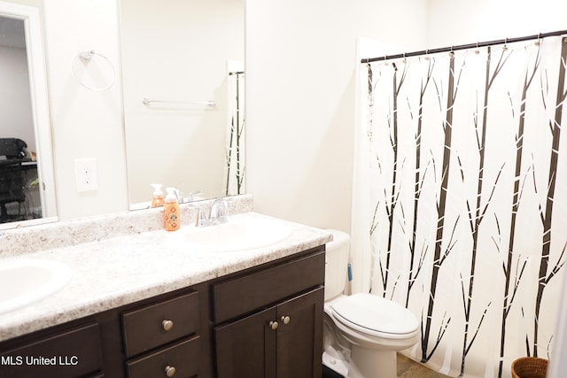 bathroom featuring double vanity, curtained shower, toilet, and a sink