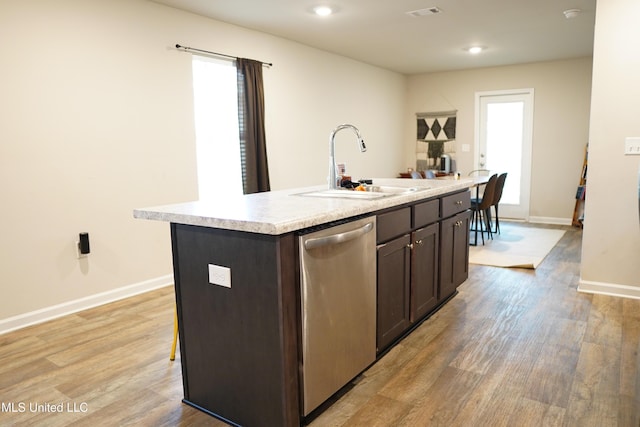 kitchen featuring dark brown cabinetry, a sink, visible vents, light countertops, and dishwasher