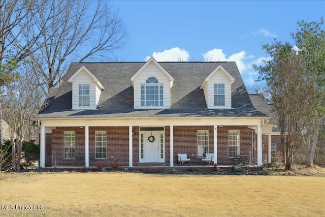 cape cod-style house with a front lawn and a porch