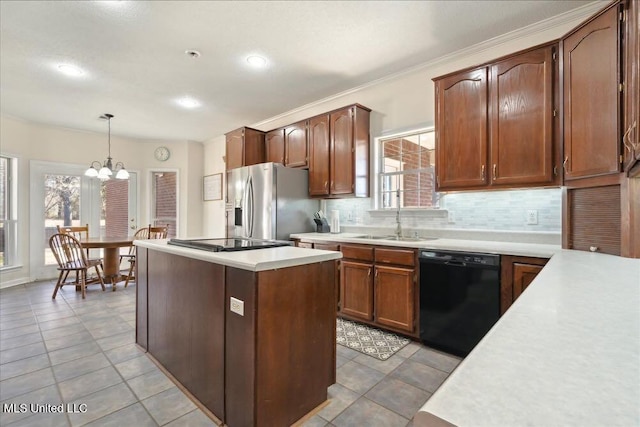 kitchen with sink, tasteful backsplash, a center island, hanging light fixtures, and black appliances