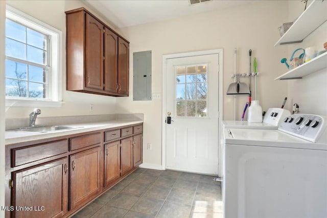 laundry room with a wealth of natural light, sink, cabinets, washing machine and clothes dryer, and electric panel