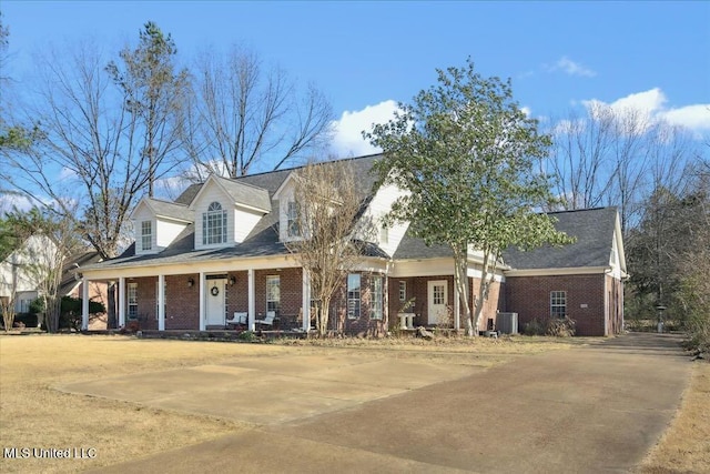 cape cod home featuring central air condition unit and covered porch