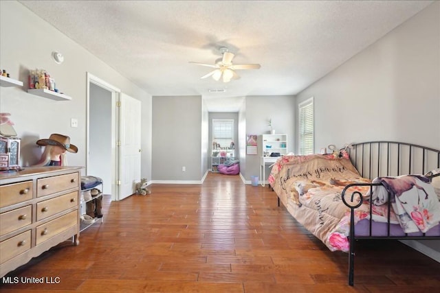 bedroom featuring hardwood / wood-style flooring, ceiling fan, and a textured ceiling