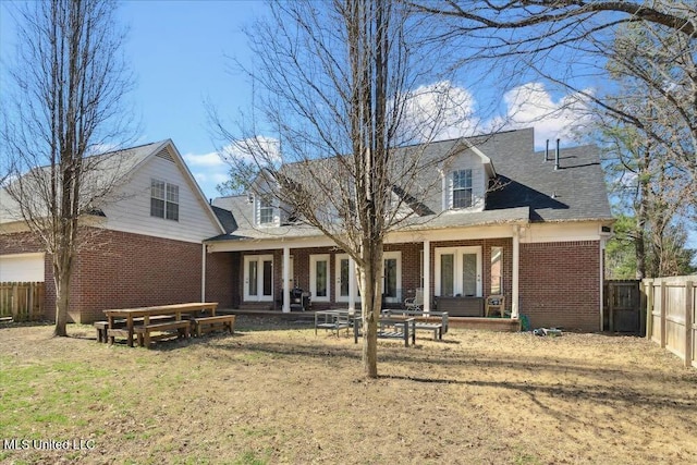 back of house featuring a yard and french doors