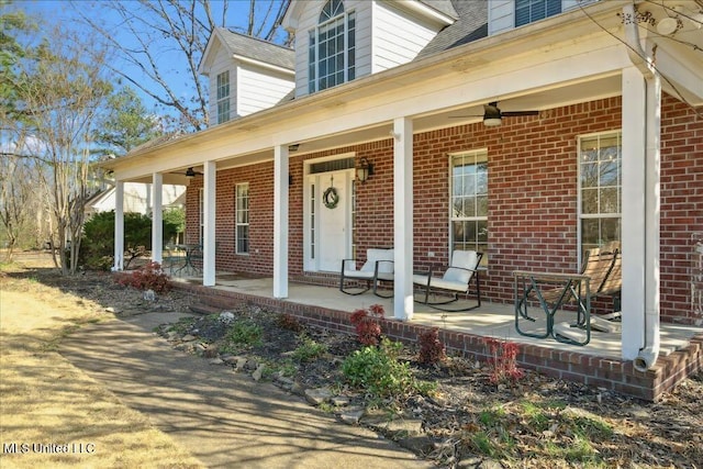 view of exterior entry with ceiling fan and covered porch