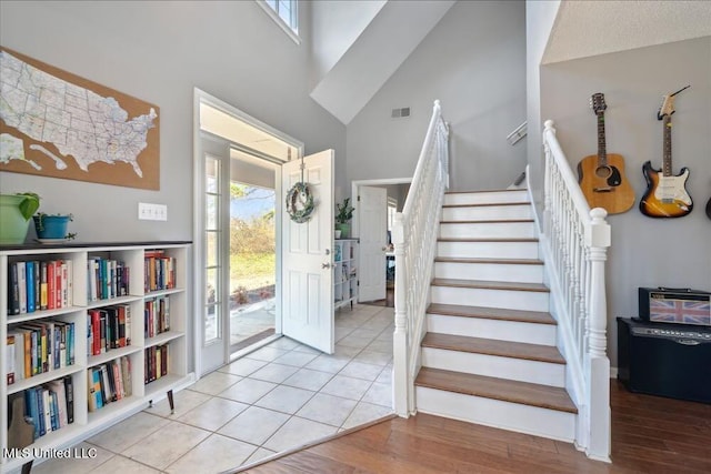 entrance foyer with a towering ceiling and light hardwood / wood-style floors