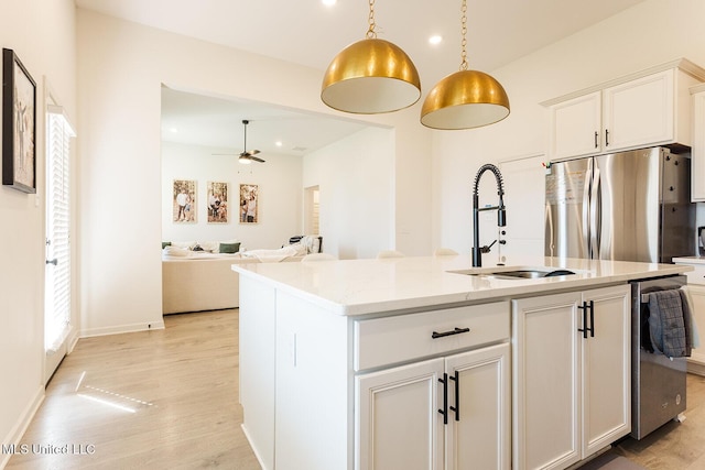 kitchen featuring ceiling fan, a sink, white cabinets, light wood-type flooring, and freestanding refrigerator