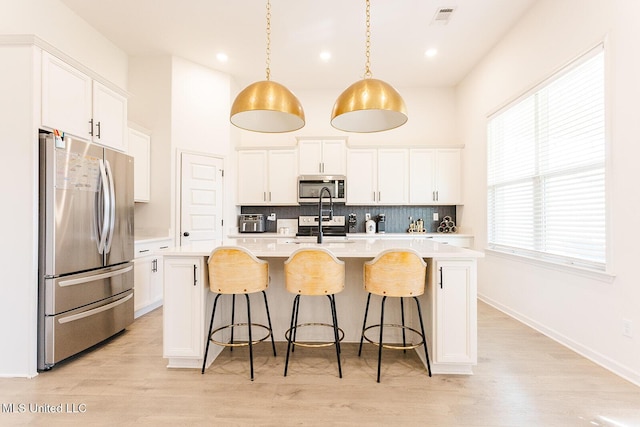 kitchen featuring white cabinetry, visible vents, stainless steel appliances, and light countertops