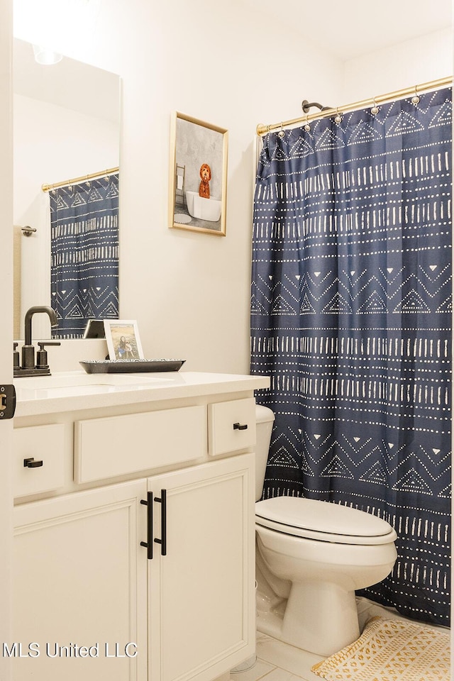 full bath featuring a shower with shower curtain, tile patterned flooring, vanity, and toilet