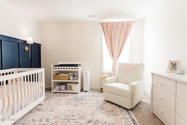 bedroom with a crib, carpet, visible vents, and baseboards