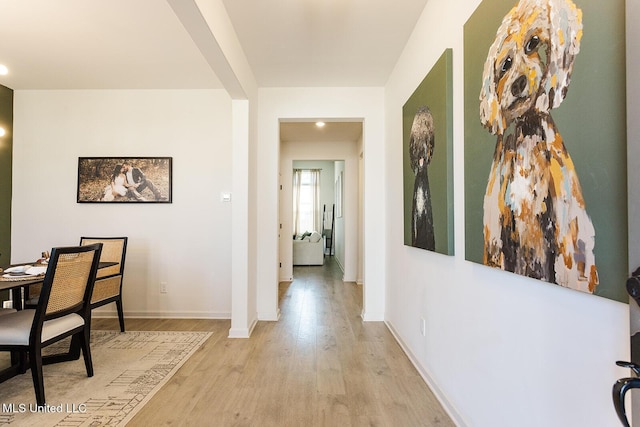 hall with light wood finished floors and baseboards