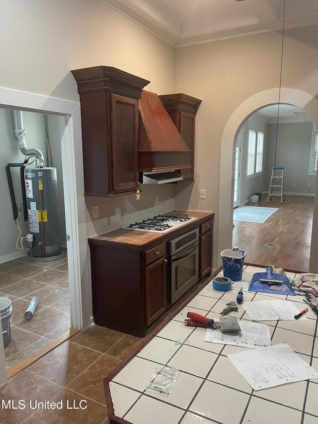 kitchen featuring custom exhaust hood, stainless steel oven, gas water heater, white gas cooktop, and dark wood-type flooring