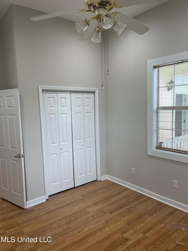 unfurnished bedroom with a closet, ceiling fan, and hardwood / wood-style flooring