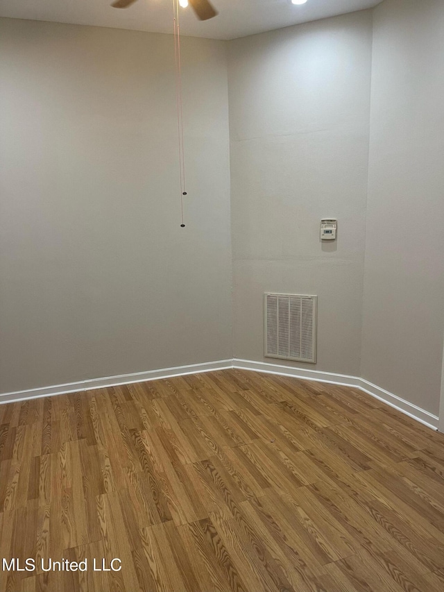 empty room with hardwood / wood-style floors and ceiling fan