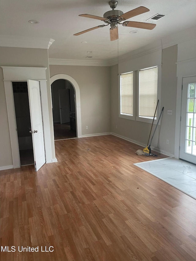 unfurnished living room with ornamental molding, wood-type flooring, and ceiling fan