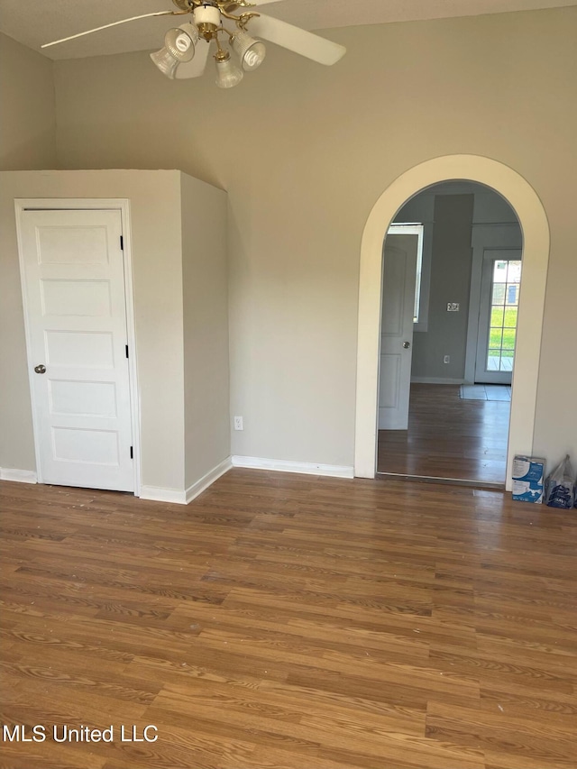 unfurnished room featuring lofted ceiling, hardwood / wood-style floors, and ceiling fan