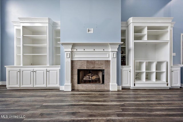 unfurnished living room featuring dark hardwood / wood-style floors and a tiled fireplace